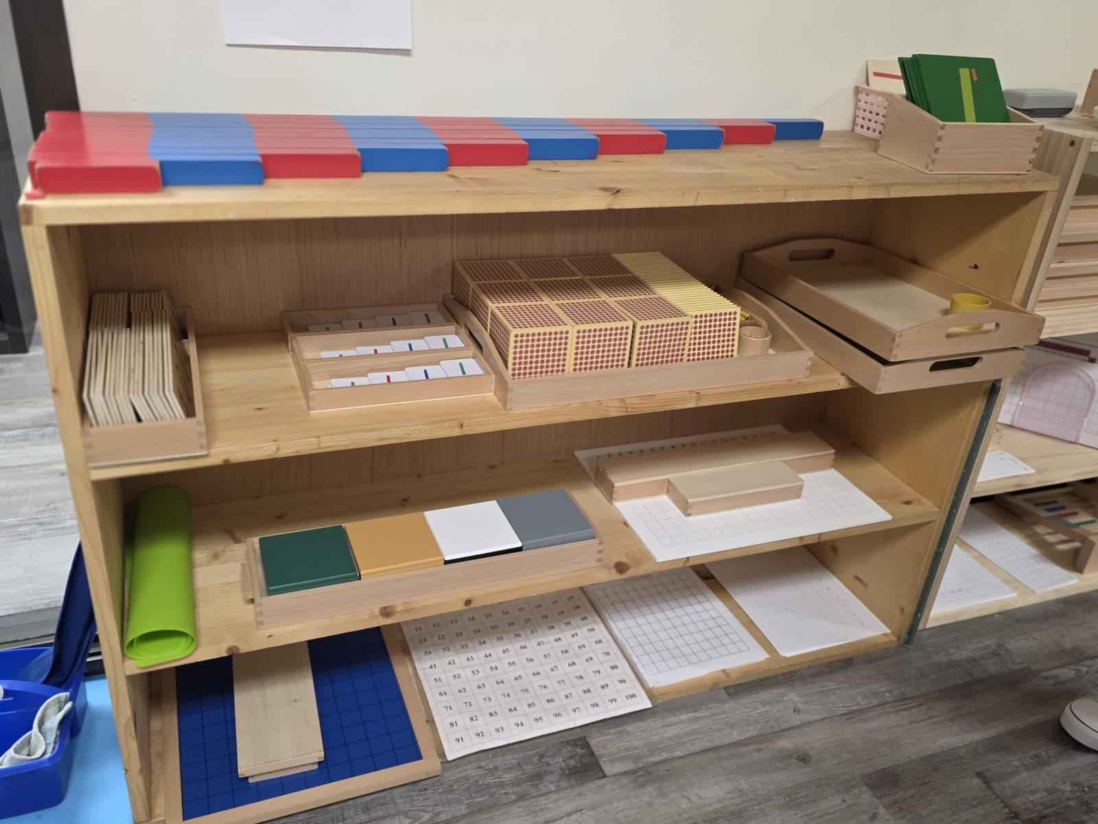 Montessori language and math materials on an Amici classroom shelf
