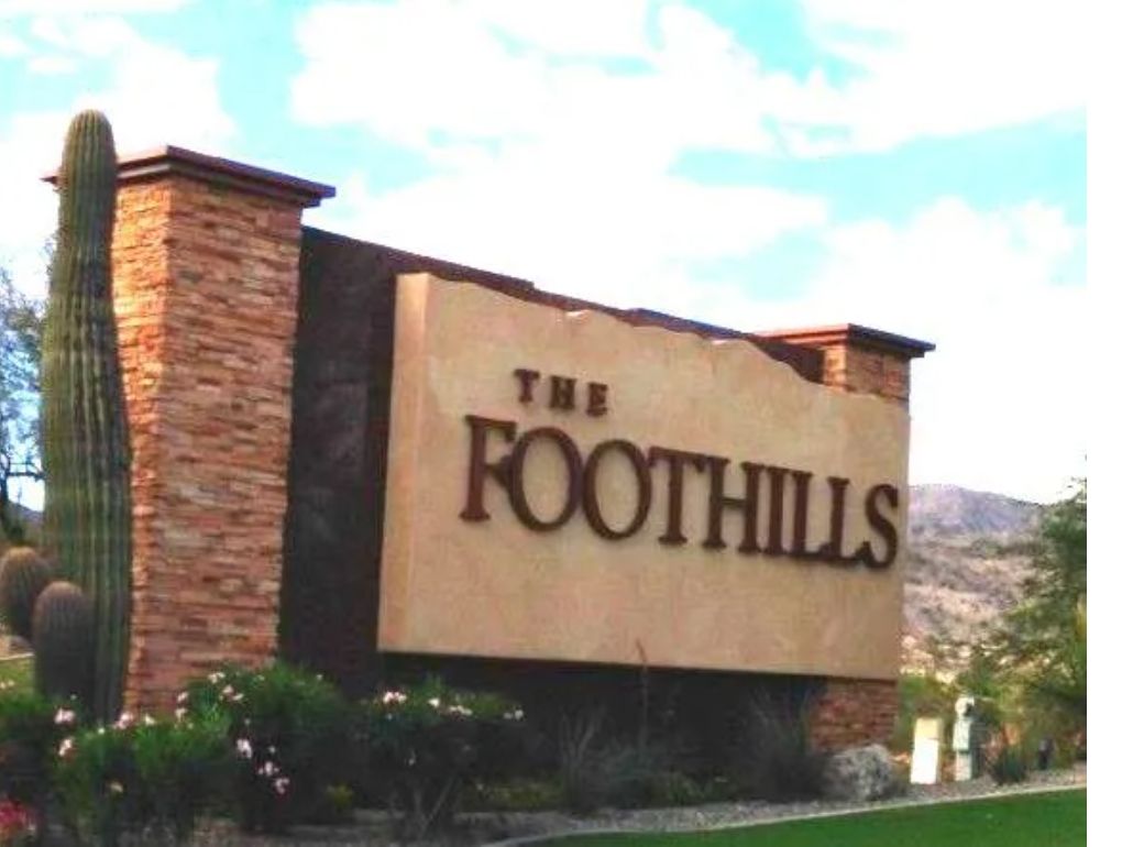 The Foothills community entrance sign in Ahwatukee, Phoenix Arizona with saguaro cactus and South Mountain